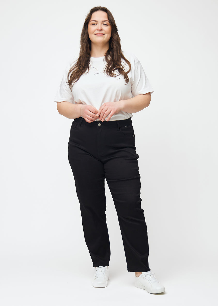 Fuldt billede af en plus-size model i sorte højtaljede regular jeans.