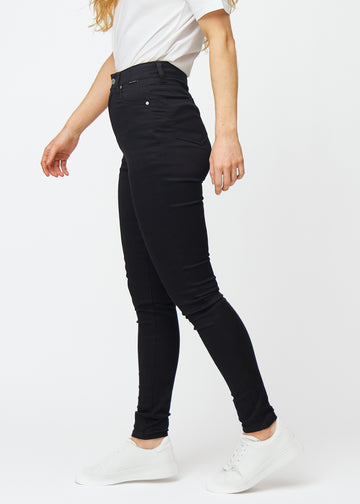 Sorte high rise skinny jeans til kvinder i farven Ravens ses fra siden på en model.