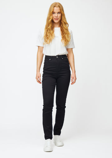 Fuldt billede af model i sorte højtaljede slim jeans.