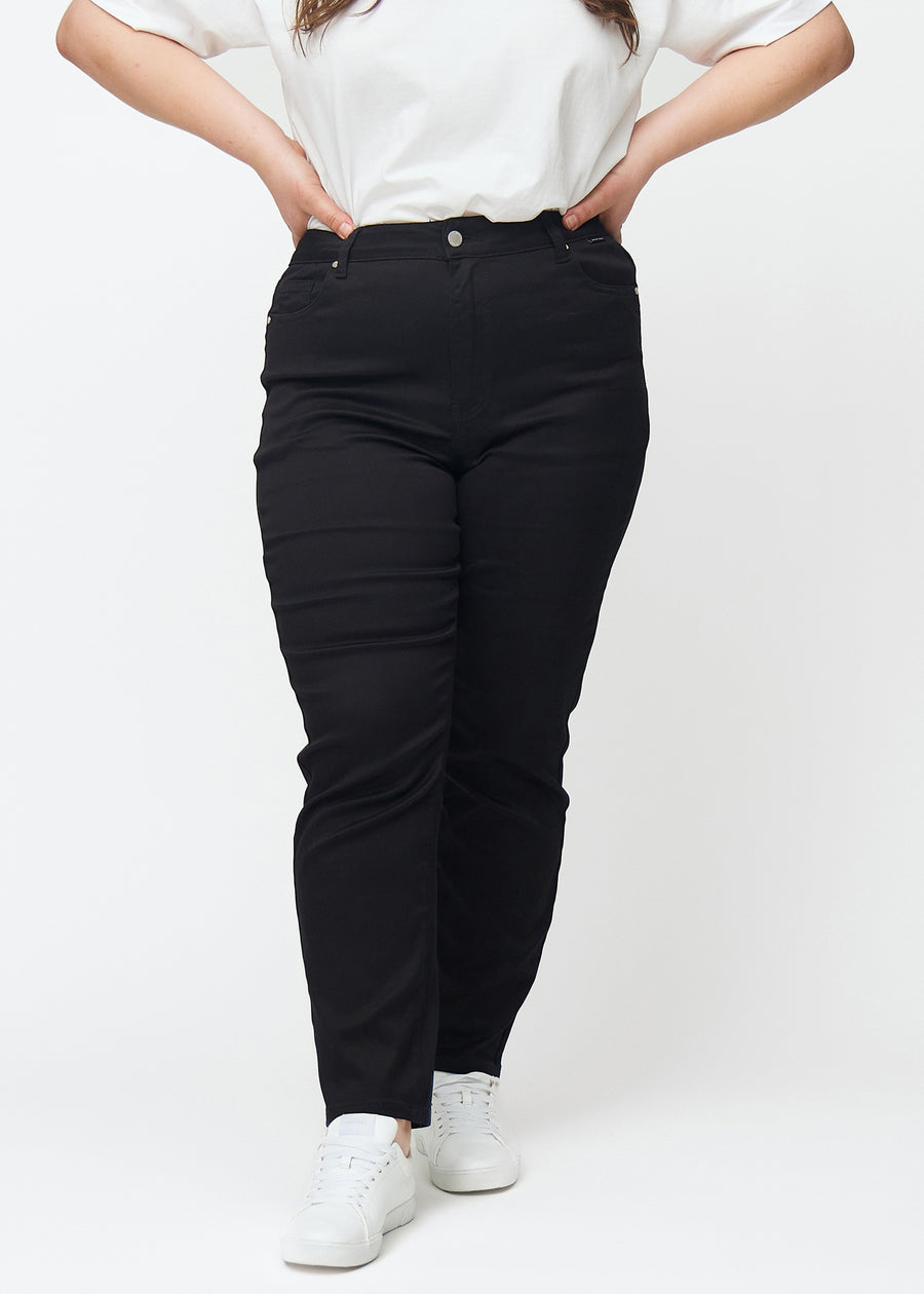 Sorte højtaljede slim jeans, modelnavn Ravens, som sidder tæt til benet, dog lidt løsere ved anklen, på en plus-size model, set forfra.