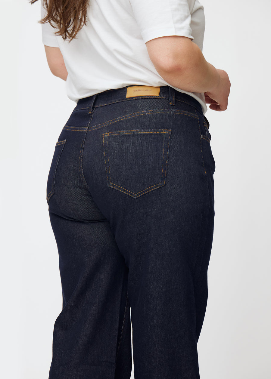 Dyb mørkeblå denim jeans til kvinder i farven Midnights set bagfra tæt på på plus-size model.