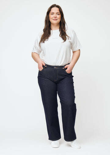 Fuldt billede af plus-size model i dyb mørkeblå denim jeans til kvinder i farven Midnights med loose pasform.