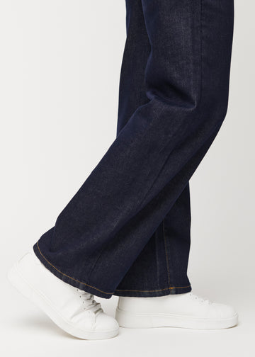 Dyb mørkeblå denim jeans til kvinder i farven Midnights med loose pasform set tæt på ved anklerne for at vise den brede afslutning.