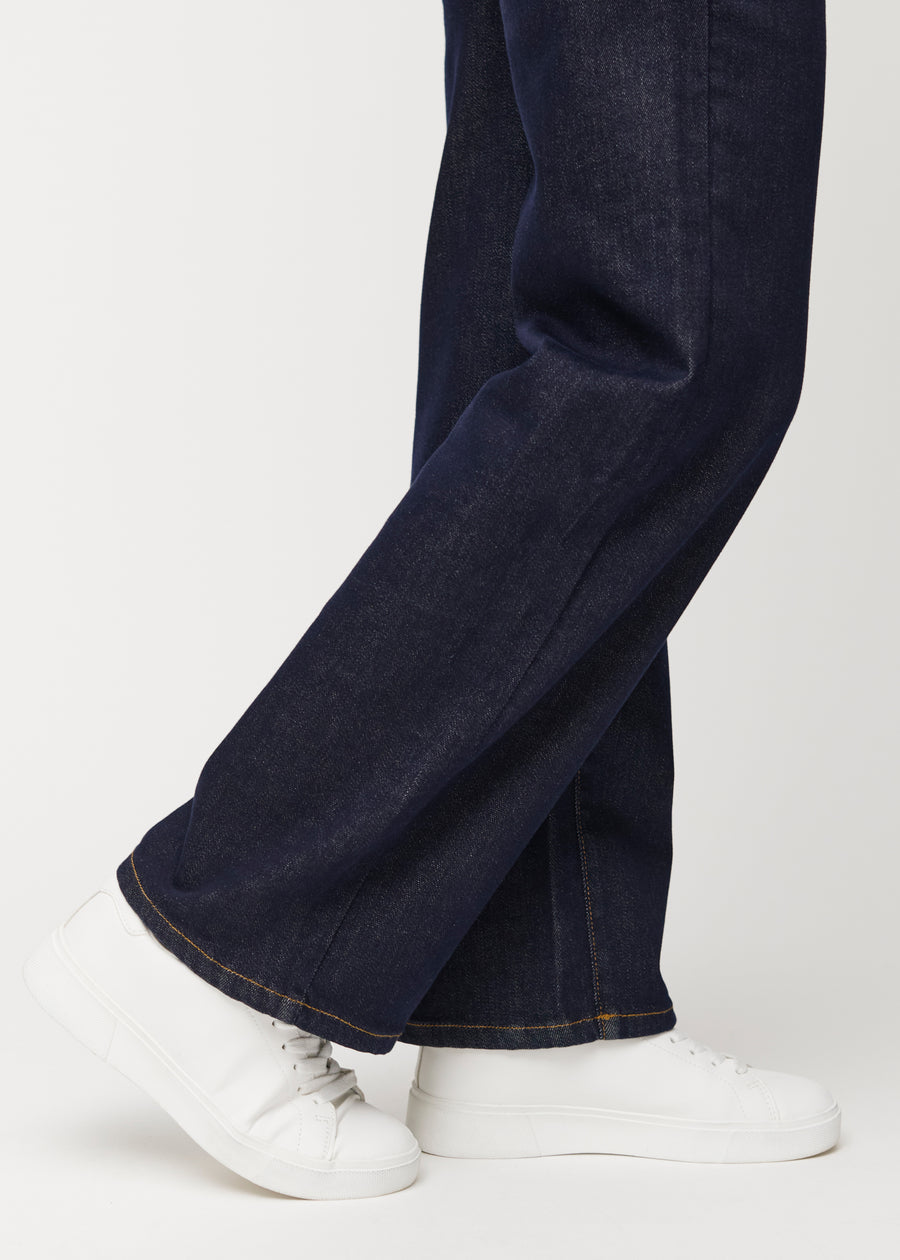 Dyb mørkeblå denim jeans til kvinder i farven Midnights med loose pasform set tæt på ved anklerne for at vise den brede afslutning.