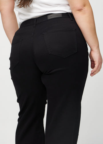 Sorte loose jeans set bagfra tæt på en plus-size model for at vise detaljer.