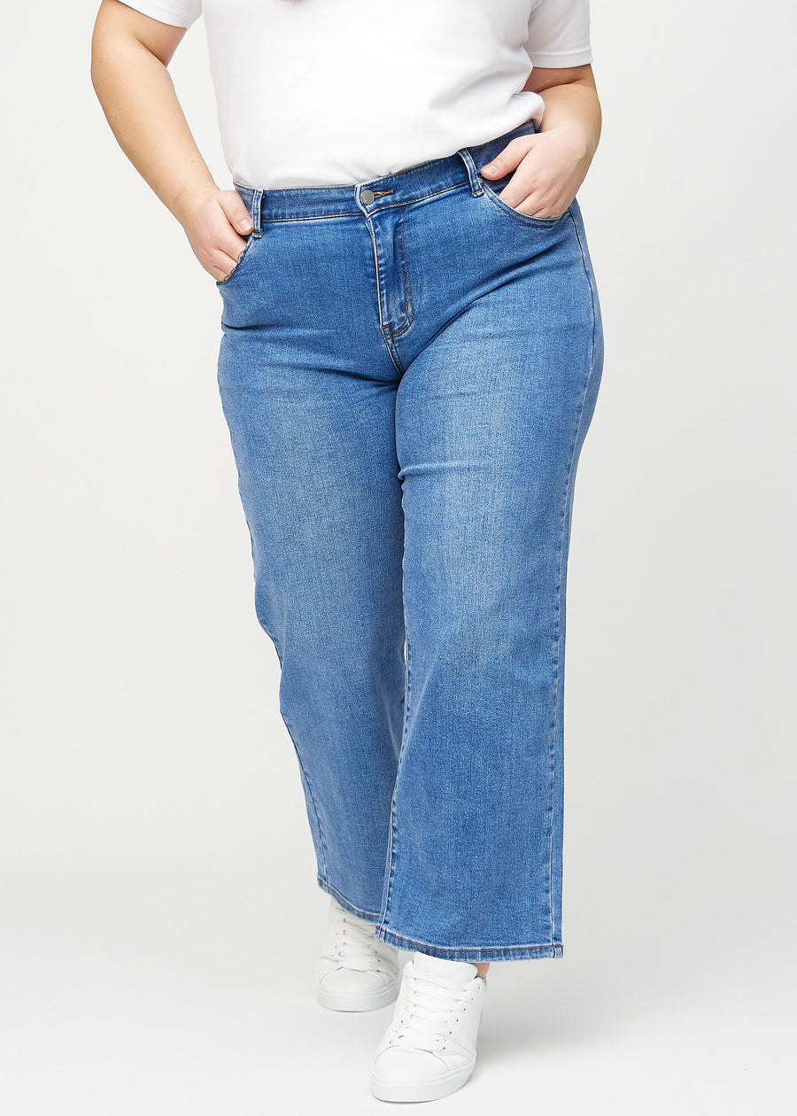 Denim loose jeans, modelnavn Rivers, som er løstsiddende med masser af vidde i benene på en plus-size model, set forfra.