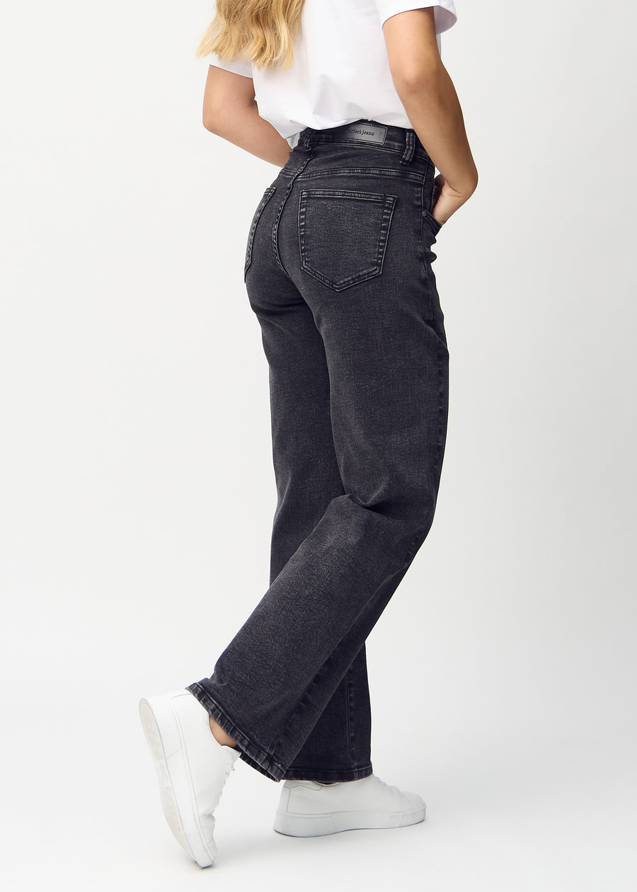 Mørkegrå denim loose jeans set bagfra, så man kan se hele produktet.