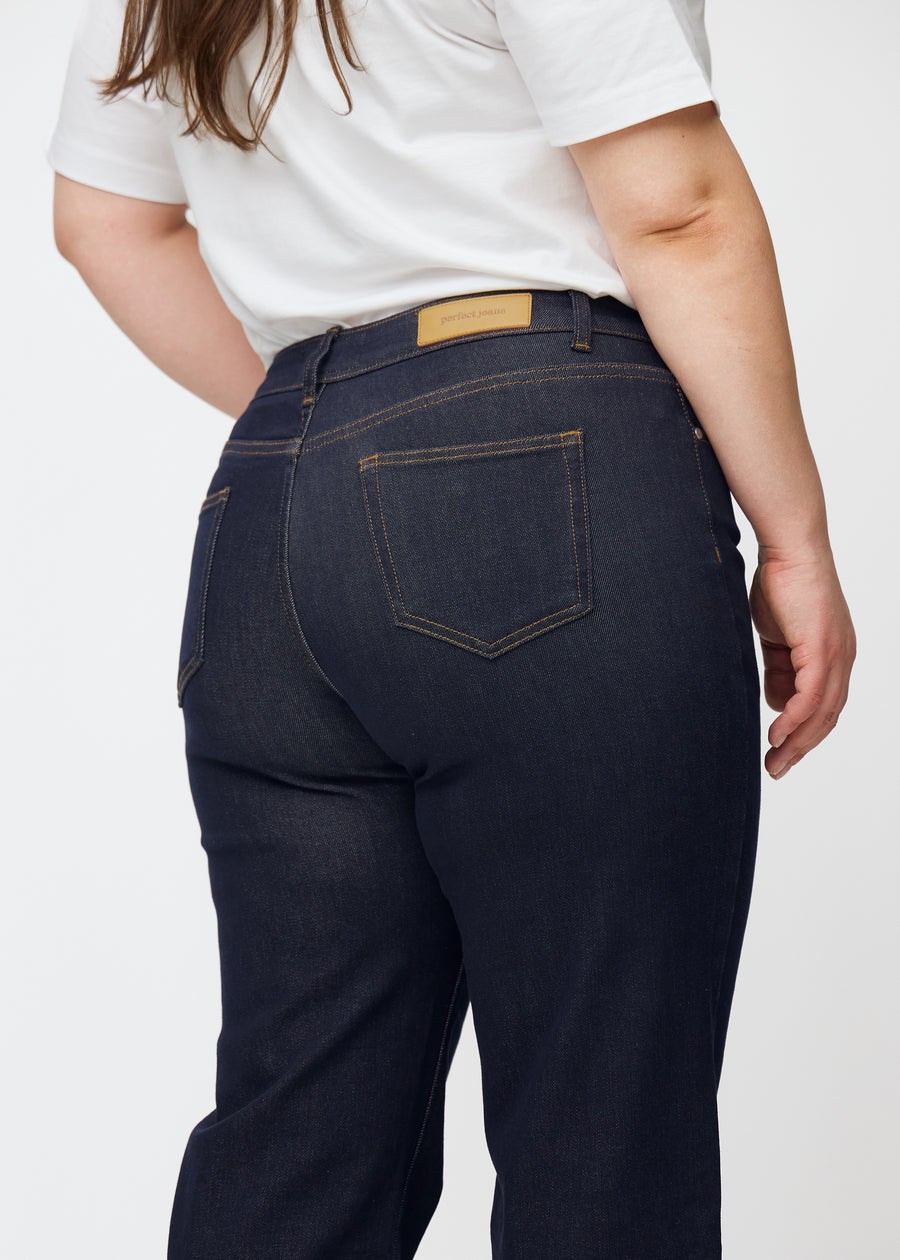 Dyb mørkeblå denim jeans til kvinder i farven Midnights set bagfra tæt på på plus-size model.