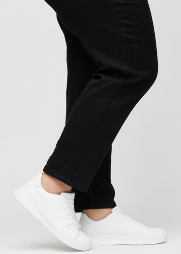 Anklerne på en plus-size model, så man kan se, hvor løst jeansene sidder i en Regular pasform.
