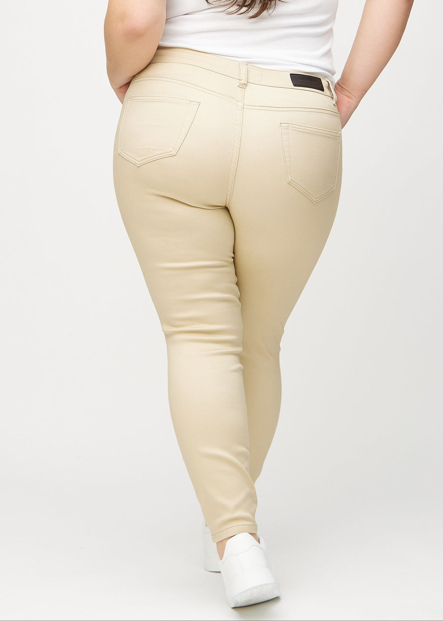 Beige skinny jeans set bagfra på en plus-size model, så man kan se hele produktet.