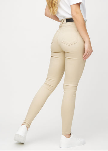 Beige skinny jeans set bagfra, så man kan se hele produktet.