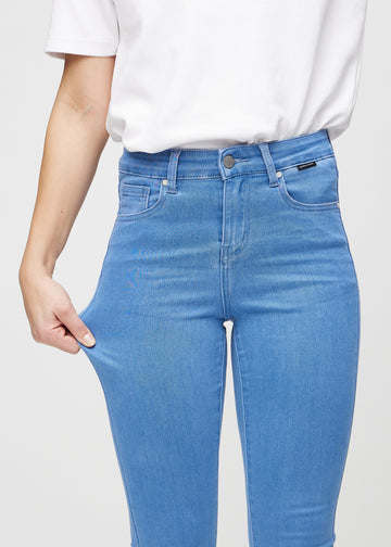Model strækker jeansene ved låret for at vise stretch.