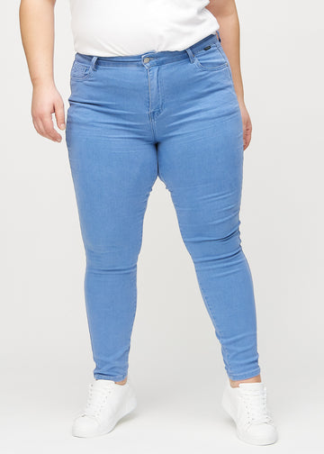 Blå skinny jeans, modelnavn Geraniums, som sidder tæt til benet på en plus-size model, set forfra.