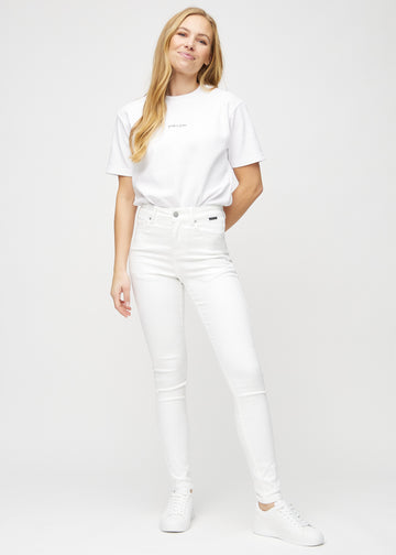 Fuldt billede af model i hvide skinny jeans.