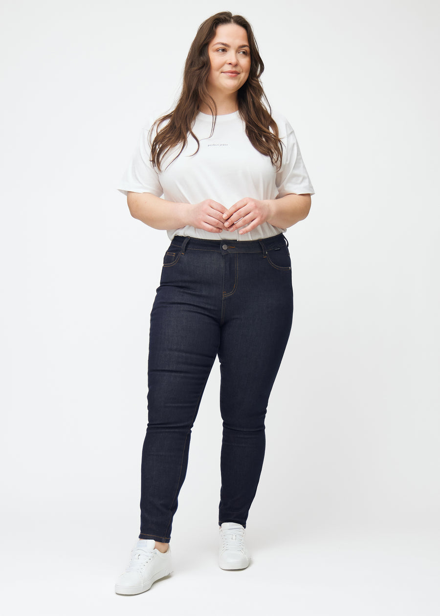 Fuldt billede af plus-size model i dyb mørkeblå denim jeans til kvinder i farven Midnights med skinny pasform.