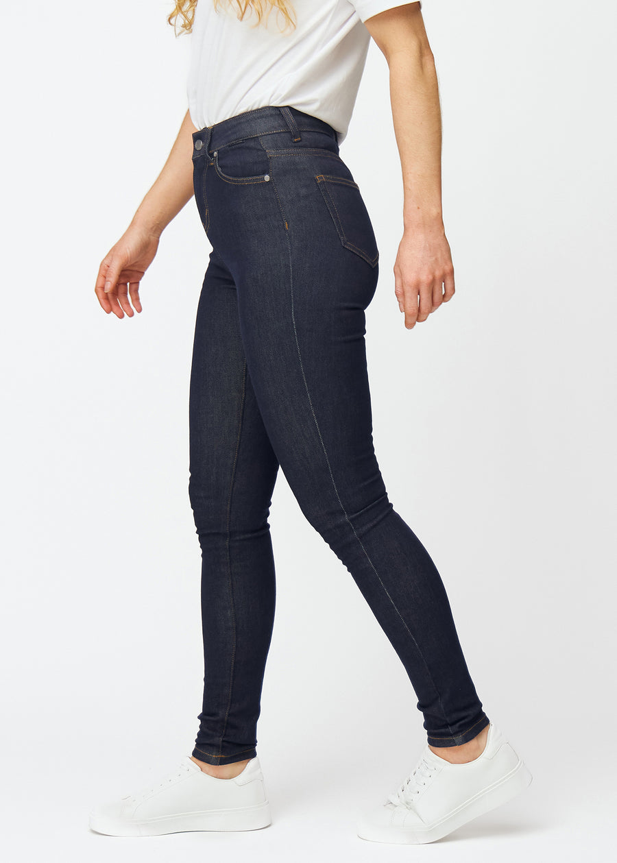 Dyb mørkeblå denim jeans til kvinder i farven Midnights med skinny pasform set fra siden på model.