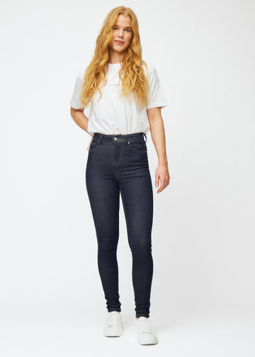 Fuldt billede af model i dyb mørkeblå denim jeans til kvinder i farven Midnights med skinny pasform.