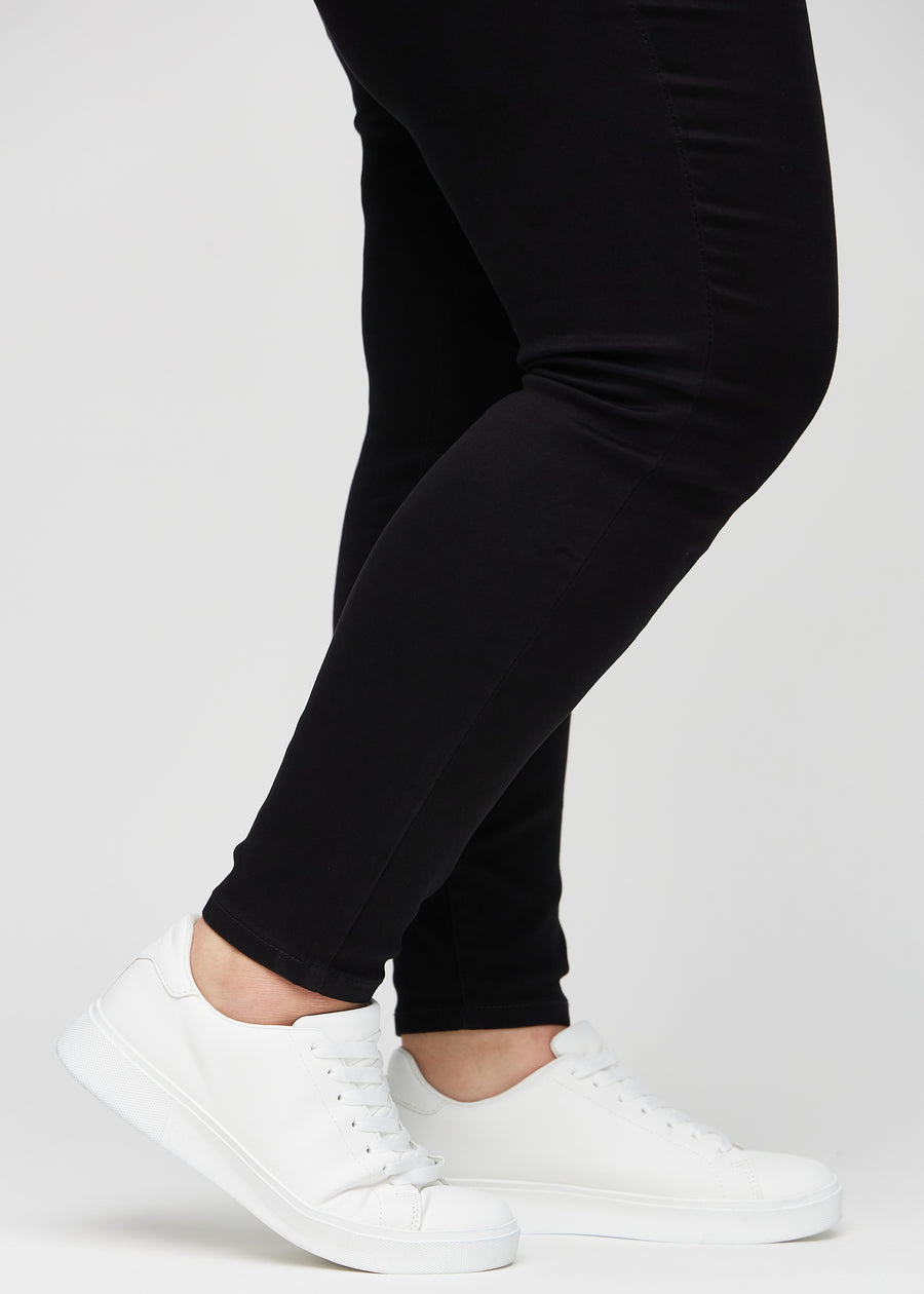 Anklerne på en plus-size model, så man kan se, hvor tæt jeansene sidder i en Skinny pasform.