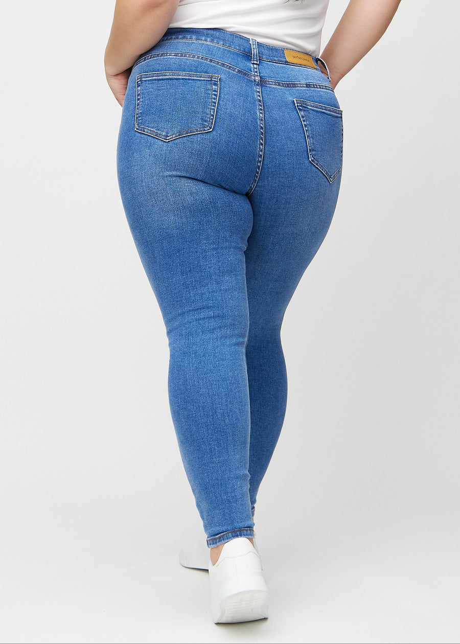 Denim skinny jeans set bagfra på en plus-size model, så man kan se hele produktet.