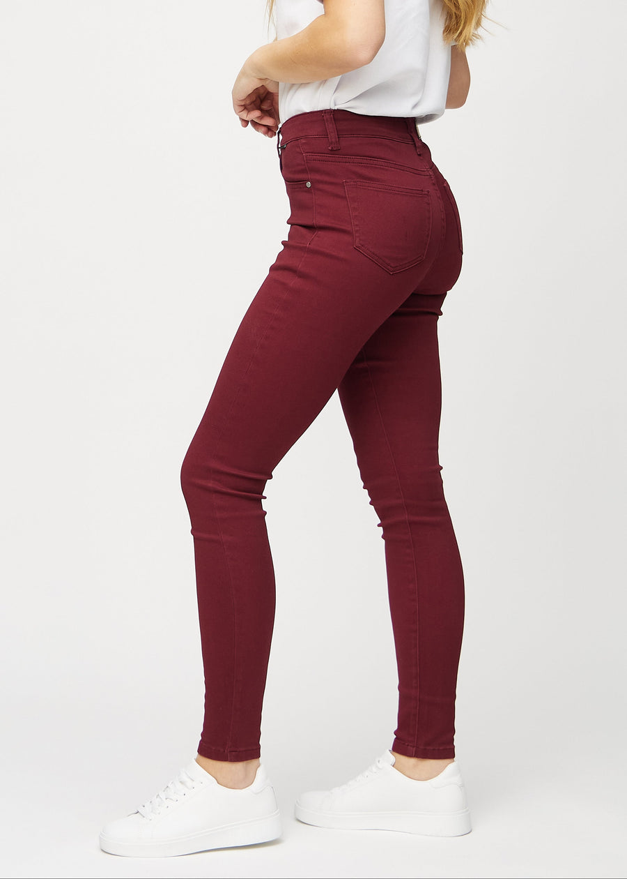 Mørkerøde skinny jeans set fra siden på model.