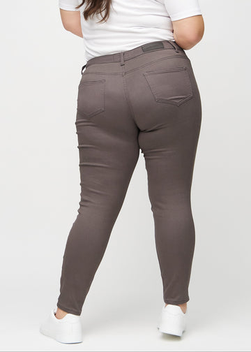 Gråbrune skinny jeans set bagfra på en plus-size model, så man kan se hele produktet.