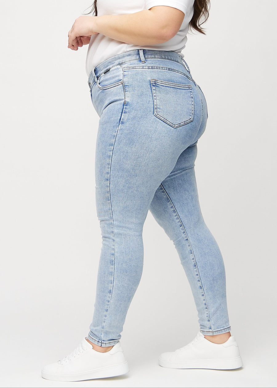 Lys denim skinny jeans set fra siden på en plus-size model.