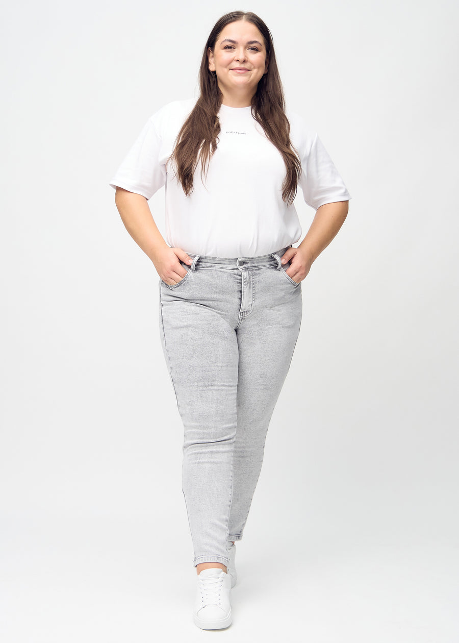Fuldt billede af en plus-size model i lysegrå denim slim jeans.