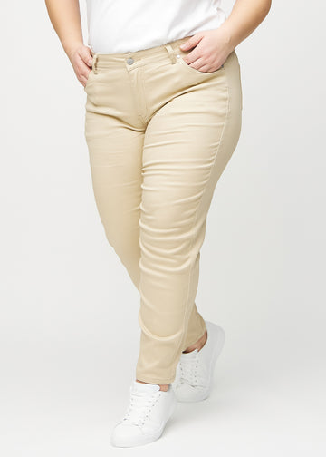 Beige slim jeans, modelnavn Gazelles, som sidder tæt til benet, dog lidt løsere ved anklen, på en plus-size model, set forfra.