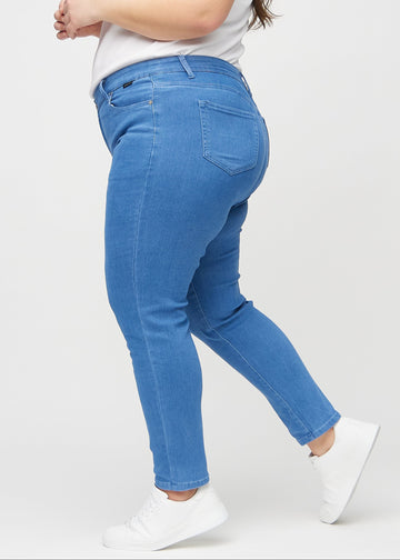 Blå slim jeans set fra siden på en plus-size model.