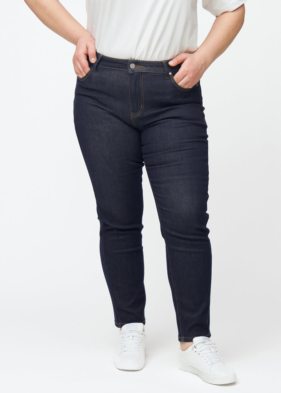 Dyb mørkeblå denim jeans til kvinder i farven Midnights med slim pasform set forfra på plus-size model.