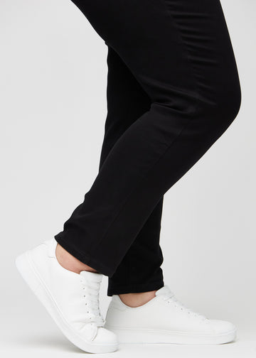 Anklerne på en plus-size model, så man kan se, hvor tæt jeansene sidder i en Slim pasform.