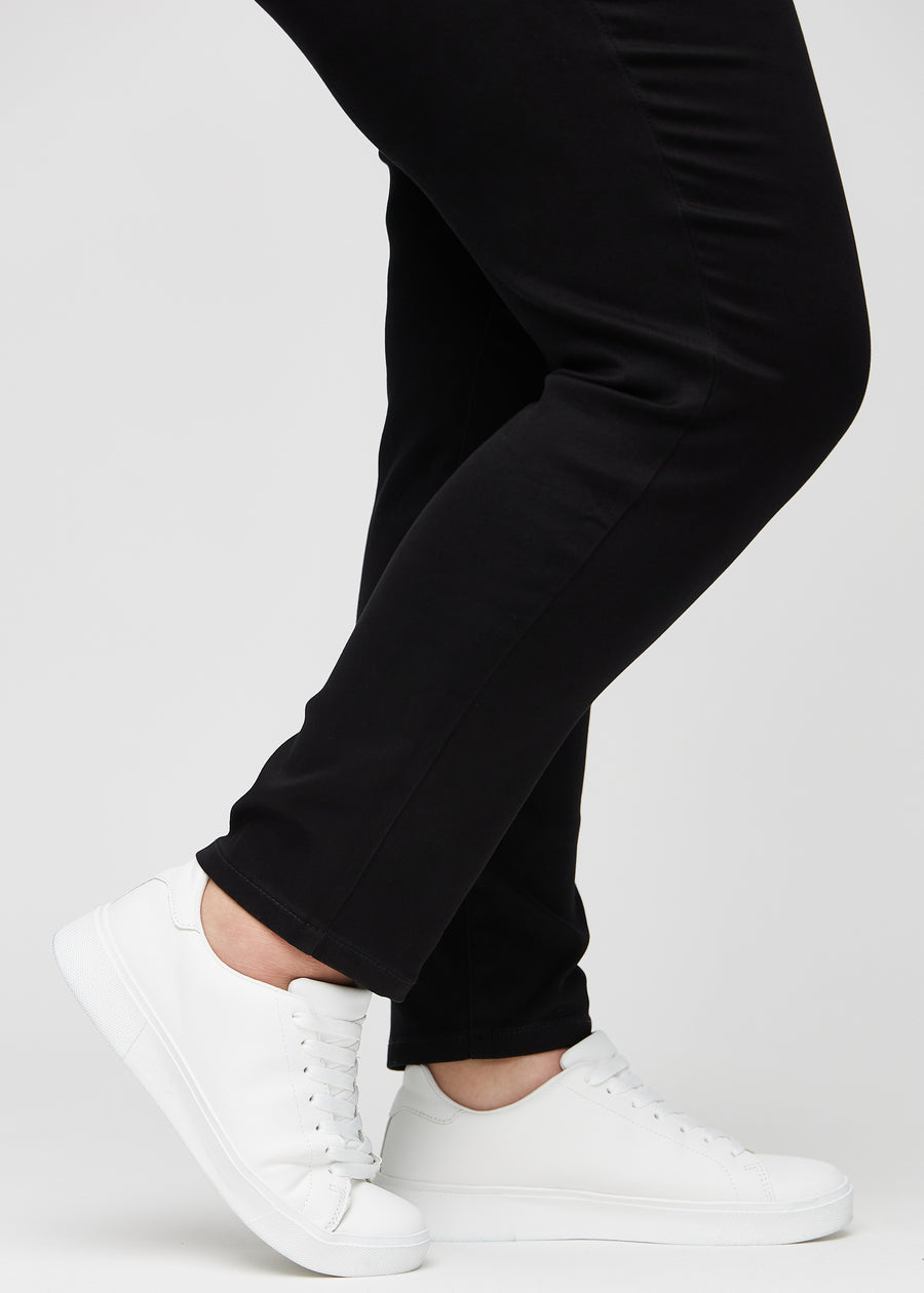 Anklerne på en plus-size model, så man kan se, hvor tæt jeansene sidder i en Slim pasform.