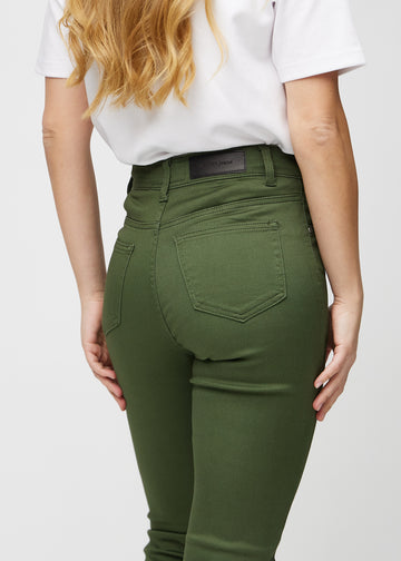 Mørkegrønne slim jeans set bagfra tæt på for at vise detaljer.