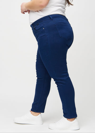 Mørkeblå slim jeans set fra siden på en plus-size model.