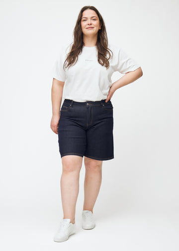 Fuldt billede af plus-size model i dyb mørkeblå denim shorts til kvinder i farven Midnights med loose pasform.