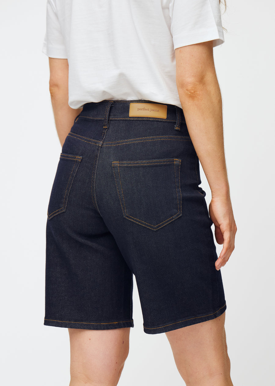 Dyb mørkeblå denim shorts til kvinder i farven Midnights set bagfra tæt på for at vise pasform og detaljer.