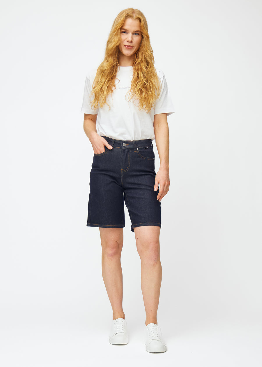 Fuldt billede af model i dyb mørkeblå denim shorts til kvinder i farven Midnights med loose pasform.