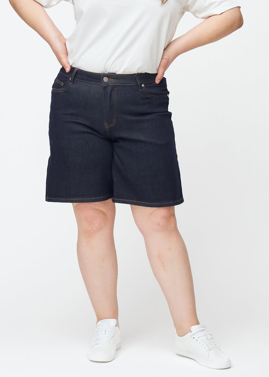Dyb mørkeblå denim shorts til kvinder i farven Midnights med loose pasform set forfra på plus-size model.