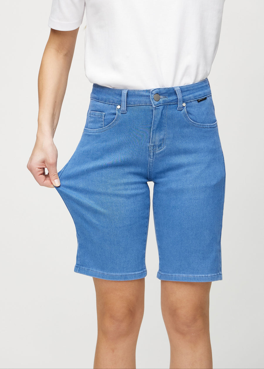 Model strækker shortsene ved låret for at vise stretch.