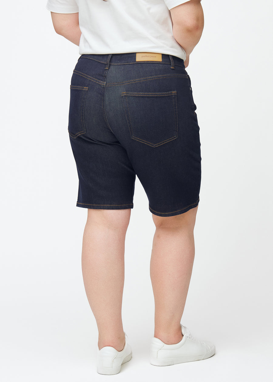 Dyb mørkeblå denim shorts til kvinder i farven Midnights set bagfra på plus-size model.