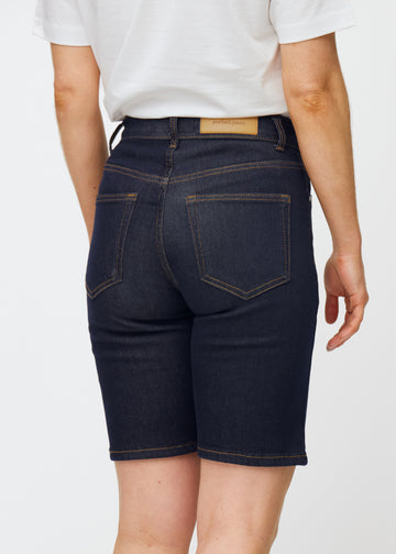 Dyb mørkeblå denim shorts til kvinder i farven Midnights set bagfra tæt på for at vise pasform og detaljer.

