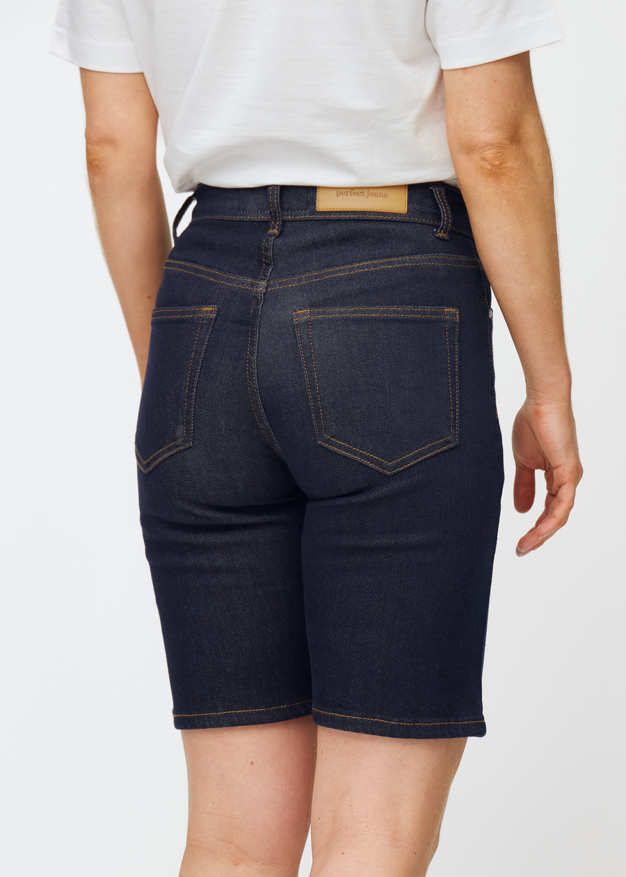 Dyb mørkeblå denim shorts til kvinder i farven Midnights set bagfra tæt på for at vise pasform og detaljer.
