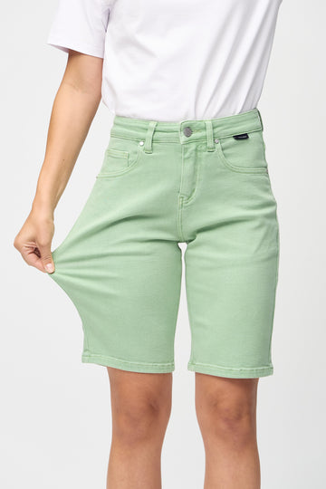 Model strækker shortsene ved låret for at vise stretch.