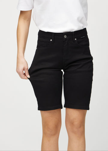 Model strækker shortsene ved låret for at vise stretch.
