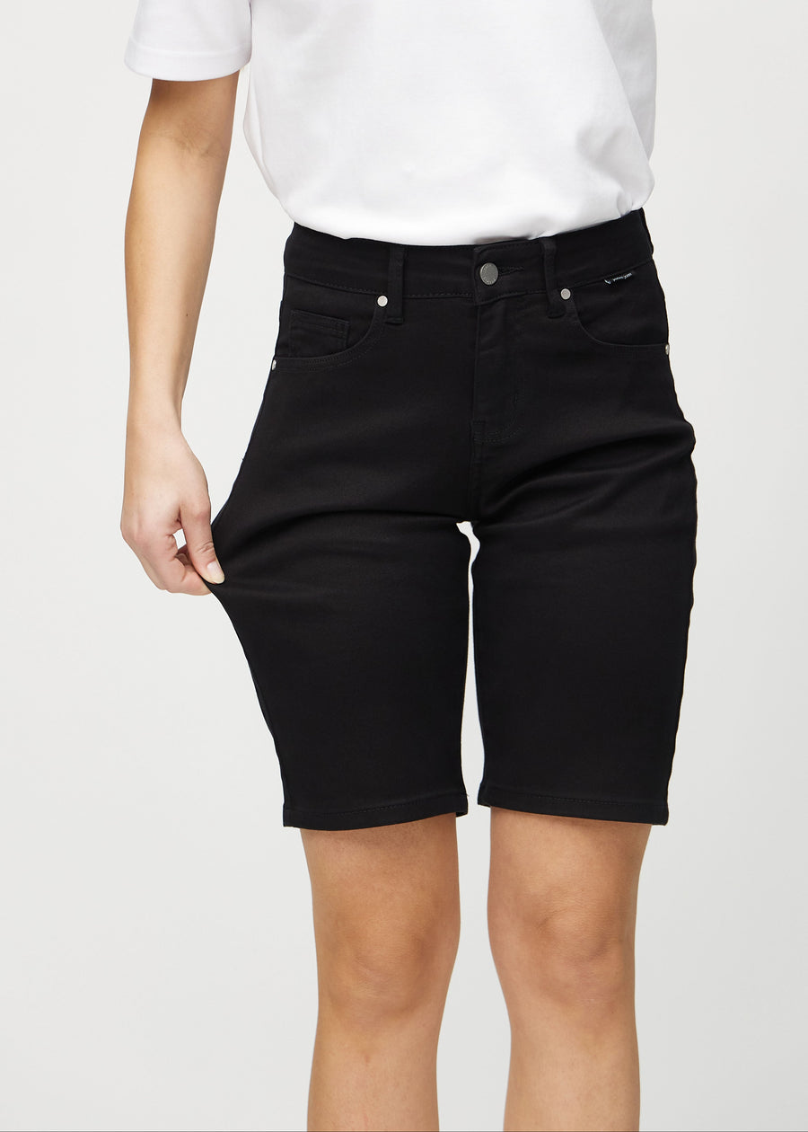 Model strækker shortsene ved låret for at vise stretch.