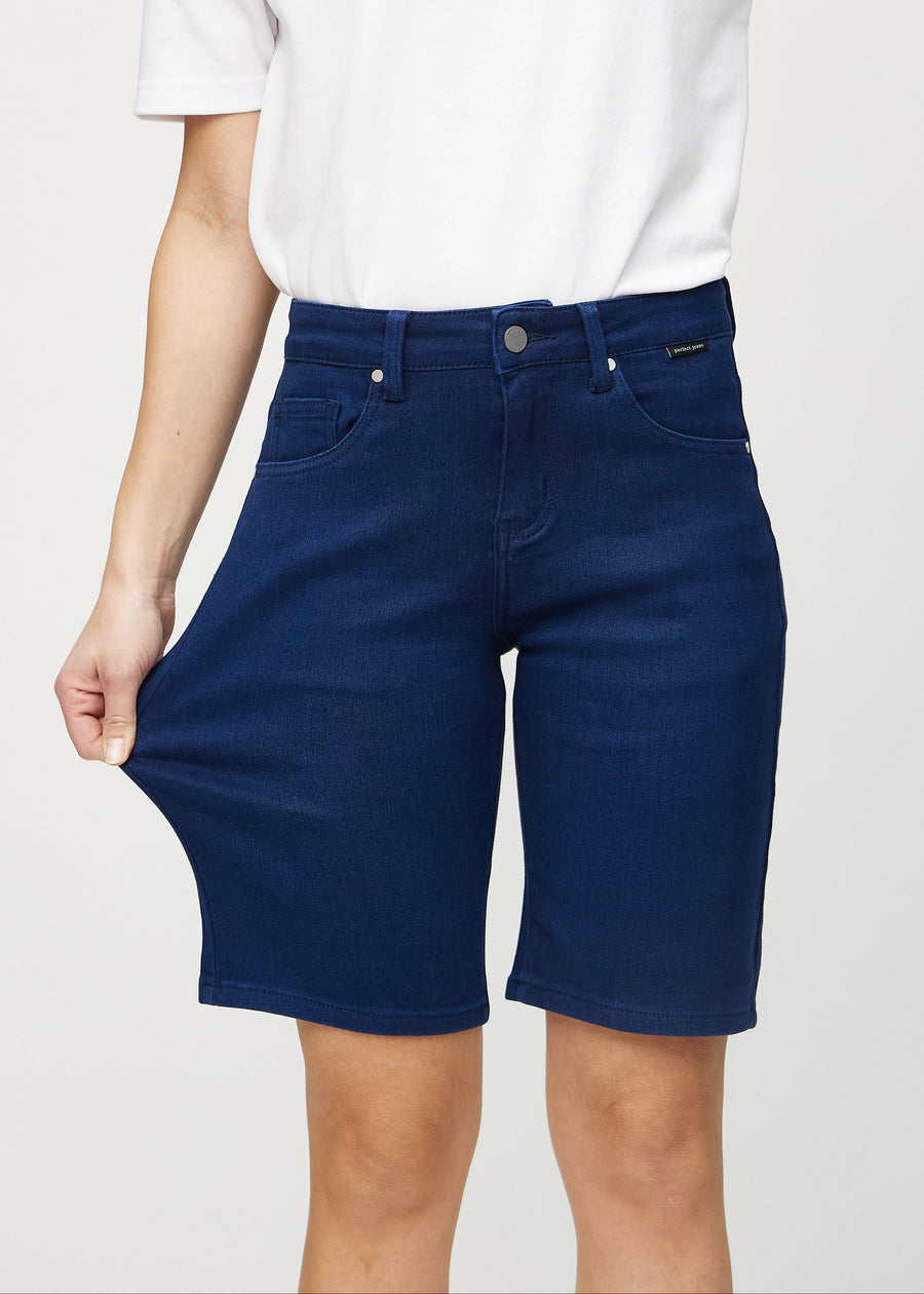 Model strækker shortsene ved låret for at vise stretch.