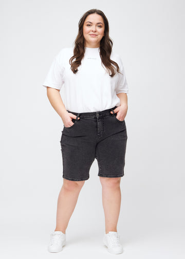Fuldt billede af en plus-size model i mørkegrå denim regular middle shorts.