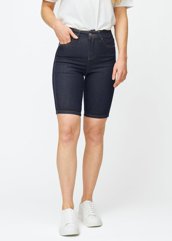 Dyb mørkeblå denim shorts til kvinder i farven Midnights med skinny pasform, der sidder tæt ved hoften og følger lårene, set forfra.