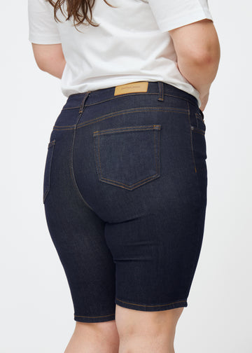Dyb mørkeblå denim shorts til kvinder i farven Midnights set bagfra tæt på på plus-size model.