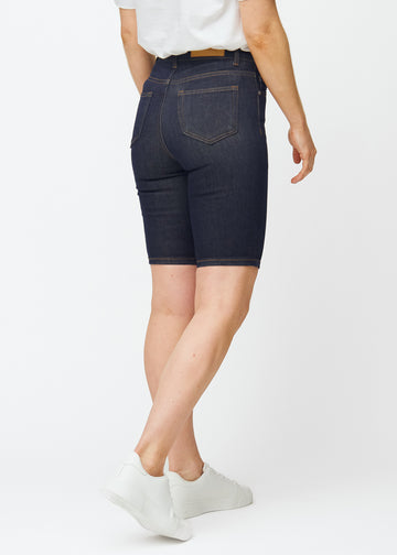 Dyb mørkeblå denim shorts til kvinder i farven Midnights set bagfra, så længden til lige over knæet kan ses.